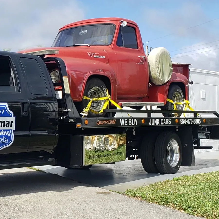 Camioneta Ford F-100 antigua roja cargada en la plataforma de Julmar