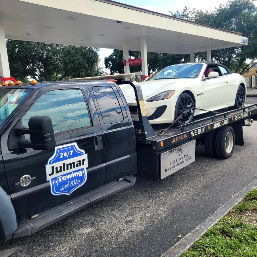 Maserati GranTurismo cargado en la plataforma de Julmar bajo el techo de una gasolinera