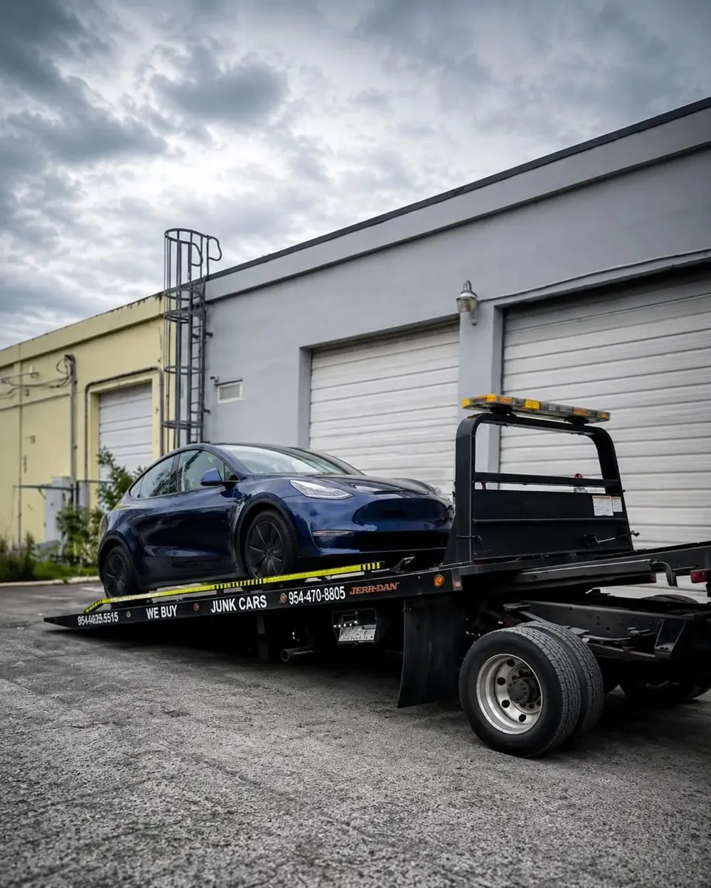 Plataforma de Julmar inclinada con un Tesla Model Y azul oscuro cargado